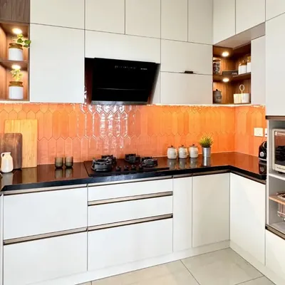 This kitchen is all about bringing warmth and style with a vibrant orange picket tile backsplash. I paired it with neutral white cabinets and a black granite countertop to create a balanced and cheerful cooking space.