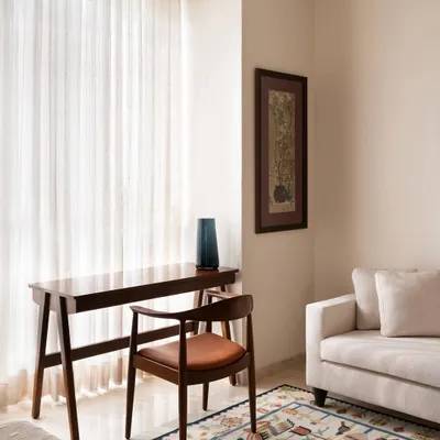 This study corner features a custom-designed desk and armchair in dark wood with a leather seat. The pieces are crafted to be elegant and functional, creating a peaceful nook for work or contemplation within the master bedroom.