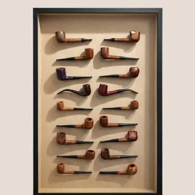 The finished masterpiece. This collection of 55 vintage pipes is mounted on an acid-free beige paper mount and housed in a black box frame with clear glass, turning a personal history into a sophisticated display.