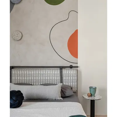 The headboard in this kids' room is set against a hand-painted abstract mural that adds a splash of color and whimsy. Terrazzo accents on the side table and lights introduce texture and fun.