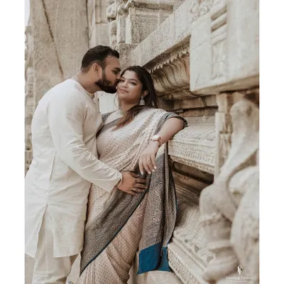 An intimate portrait of a couple during their maternity shoot at a temple. The husband's gentle kiss on her cheek captures a moment of pure love and affection.