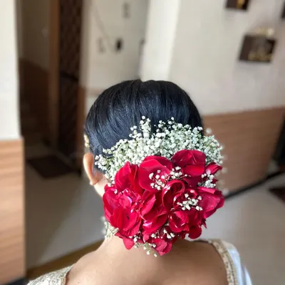 A classic bridal bun made perfect with a combination of vibrant red roses and delicate baby's breath. This is a timeless and elegant choice for any wedding day.