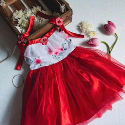 A beautifully styled shot of one of my favorite red and white floral dresses. The combination of the floral print, red tulle, and satin ribbon straps creates a truly romantic and festive look.