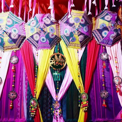 This Mehndi backdrop is all about vibrant colors and traditional charm. I used colorful drapes in pink, yellow, and green, and hung decorative Rajasthani umbrellas to create a festive and joyful photo corner.