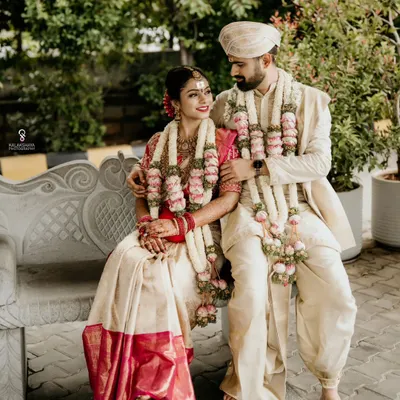 A classic portrait of the bride and groom in their traditional South Indian wedding attire, sharing a quiet moment together.