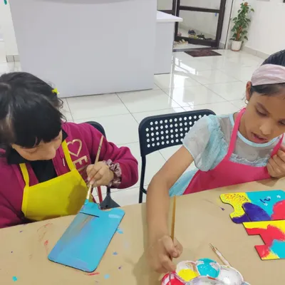 Kids working on their personalized desk calendars. This is a great activity that combines painting with a useful item they can keep all year.