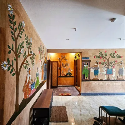 This wide view shows how the different Cheriyal scenes connect to create a flowing narrative along the corridor of this Andhra-style apartment, transforming it into a village path.