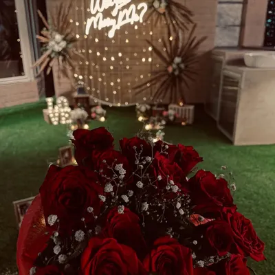 I was honored to be a part of this magical moment. A beautiful bouquet of red roses in the foreground of a romantic "Will you Marry Me?" proposal setup I helped create.