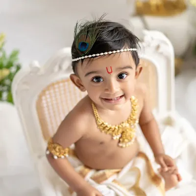 Your little one as a divine little Krishna. This close-up shot captures the innocent smile and bright eyes that make these themed sessions so magical and memorable.