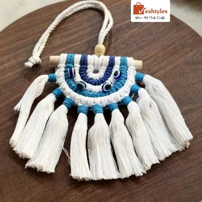 This is my classic evil eye car charm, designed to protect you on your journeys. It features the traditional blue and white colors, with intricate knotting and a wooden dowel. It's a perfect gift for yourself or a loved one.