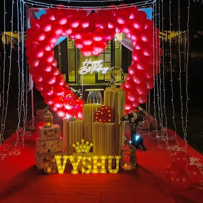 Our signature romantic cabana is perfect for an unforgettable surprise. It features a canopy of fairy lights, a red carpet walkway, and a stunning heart-shaped arch made of red balloons.