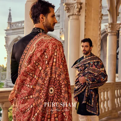 The fabric of his attire tells a story of power and pride. In the palace of dreams, he is the sovereign, adorned in a classic bandhgala and a magnificent red and gold shawl, draped in the whispers of time.