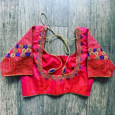 A pink raw silk blouse with a square neckline. The embroidery on the sleeves is done with blue and gold thread for a nice contrast.