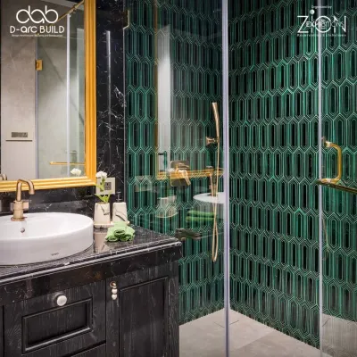 This bathroom in 'The House of Arcs' features striking emerald green geometric tiles, black marble, and brushed gold fixtures. The design is bold and luxurious, creating a dramatic and memorable space.