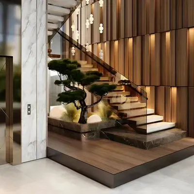 A stunning staircase design featuring a built-in planter for a bonsai tree. The combination of marble, wood, and dramatic lighting turns this functional element into a work of art.