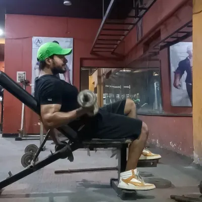 Perfecting the form on a seated dumbbell curl. This exercise is excellent for building bicep strength and size.