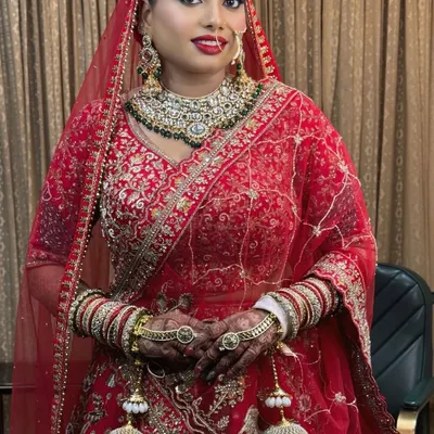 A full-length view of this stunning bride in her traditional red lehenga. The makeup is designed to be sweat-proof and picture-perfect, lasting through the entire ceremony.