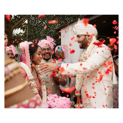 A candid moment of joy as the couple is showered with rose petals by their friends and family. This is the kind of spontaneous happiness we love to capture.