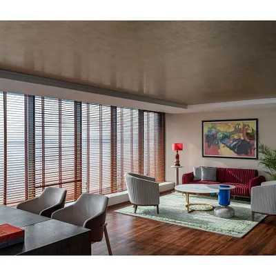The MD's suite in 'The Office with A View' combines a meeting area and a private cabin. We repurposed much of the existing furniture while adding new elements like champagne leafing on the ceiling to create a refreshed, sophisticated look.