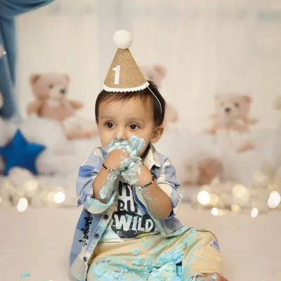 Look at those little hands covered in blue cake! This is the best part of a cake smash session, the pure, messy joy. This little boy is having the time of his life during his pre-birthday shoot in our Jaipur studio.