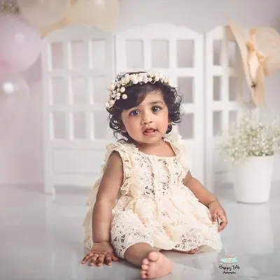 This little girl's portrait session is so sweet and classic. The soft pastel balloons and floral details create a beautiful, dreamy atmosphere for her milestone photos.