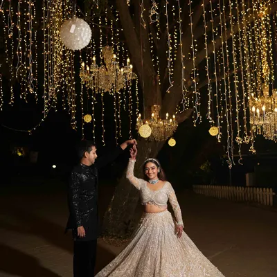Dancing under a sky of your own. For this 'Starry Night' Sangeet, we hung thousands of fairy lights and crystal chandeliers from the trees to create a truly magical, open-air dance floor.