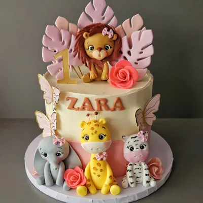 All things pink and pretty for Zara's first birthday. This jungle cake features adorable, hand-sculpted baby animals like a lion, giraffe, elephant, and zebra, all with cute pink bows.