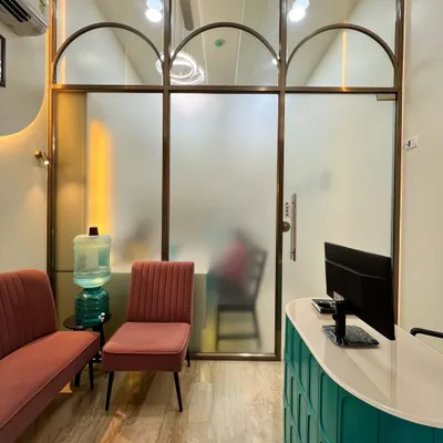 The entrance to the doctor's cabin at the Powai dental clinic, featuring frosted glass with arched details. This design choice provides privacy while allowing light to filter through, maintaining a bright and open feel in the commercial space.