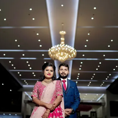 A classic wedding reception look. The couple stands against a beautiful floral wall, ready to greet their guests in a hall that I've decorated to feel grand and welcoming.
