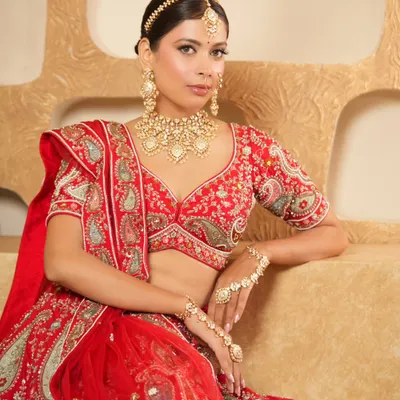 A classic bridal portrait featuring a stunning gold-look polki set. The ensemble includes a detailed choker, matching earrings, and a maang tikka, creating a complete and regal look for your wedding day.