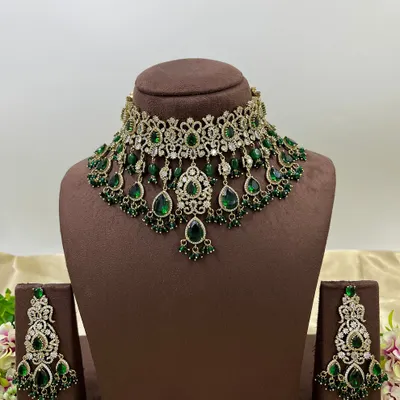 A heavy bridal choker set in a stunning emerald green. This design features multiple layers of stones and bead droppings, complete with matching oversized earrings, making it a comprehensive offering for your bridal customers.