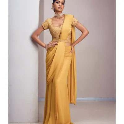 A modern drape in a sun-kissed yellow hue exudes confidence and effortless style. This pre-draped saree is perfect for those who love the elegance of a saree but prefer a fuss-free, contemporary silhouette for festive events.