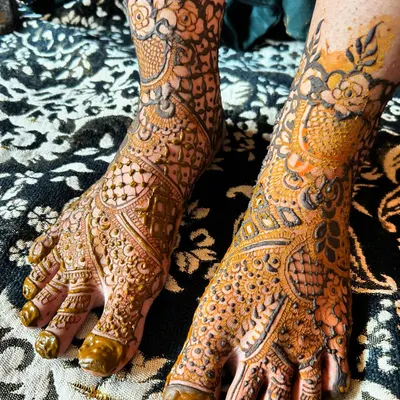 A beautiful and intricate bridal foot mehendi design. The pattern covers the entire top of the foot and extends to the ankle, creating a look as detailed as the hands.