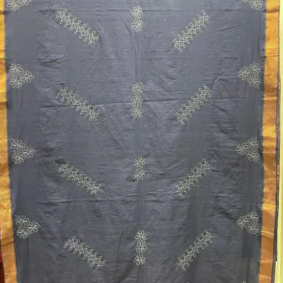This is a custom-made Mangalgiri saree featuring Sashiko embroidery, a traditional Japanese craft. The geometric patterns are created with a simple running stitch, resulting in a piece that is both elegant and minimalist.