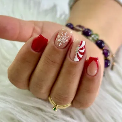 Christmas nails with main-character energy. This set is a statement, featuring classic crimson, a crisp snowflake detail, a candy-cane twist, and a bold red French tip.