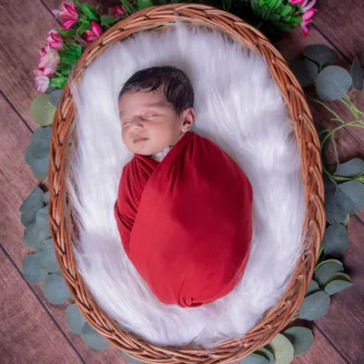 Wrapped snugly in red, this little one is a perfect gift. I use soft, stretchy wraps to keep your baby feeling secure and calm, which helps them sleep peacefully during our session.