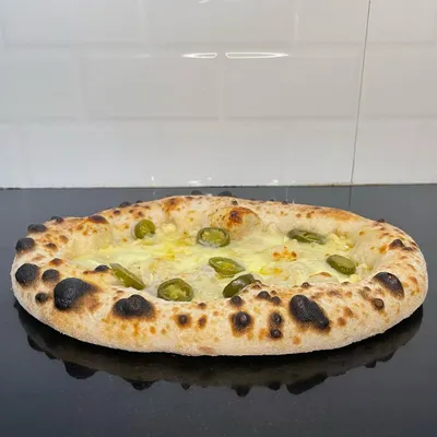 My contemporary-style jalapeño garlic bread. I use my signature pizza dough to create a light, chewy bread topped with garlic butter, herbs, and spicy jalapeños.