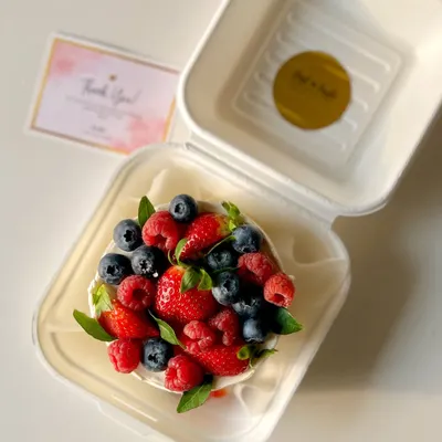 An overhead shot of my seasonal berry-loaded bento cake. It's generously topped with fresh strawberries, blueberries, and raspberries for a burst of flavor and color.