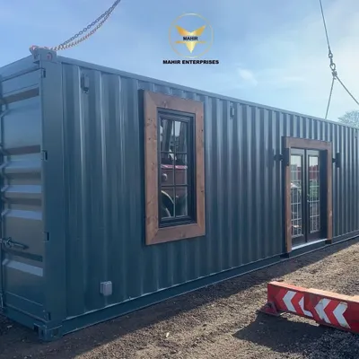 A custom container home, successfully delivered and placed on-site. The combination of industrial steel with warm wood accents and French doors creates a modern and inviting living space.