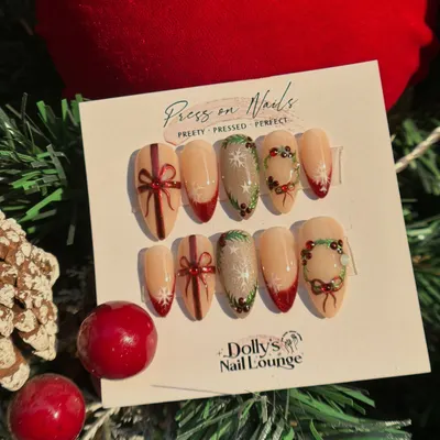Get into the holiday spirit with these festive press-on nails. This set features hand-painted wreaths, bows, and a touch of red French tip.