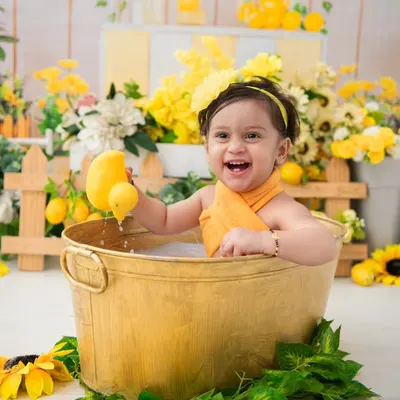 A lemon and sunflower themed milk bath. The bright yellow colors and the baby's happy expression make this a wonderfully cheerful and vibrant portrait.