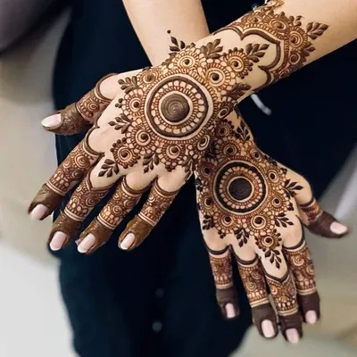 A bold and beautiful mandala design on the back of the hand. The dark center really makes the pattern stand out.