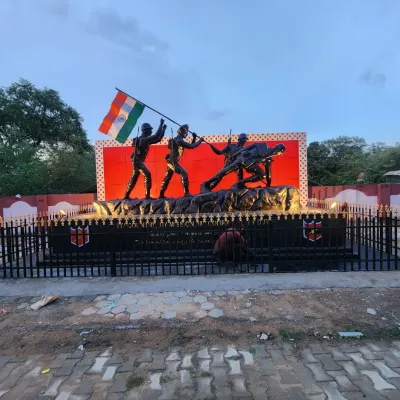 A wider view of the Indian Army memorial in Jaipur, showing the complete installation with its base and surrounding fence. The monument is a prominent landmark, built to honor our soldiers.