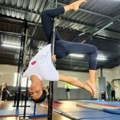 Persistence meets elegance. This is a celebration of strength and grace, as this young student holds a perfect inverted stag pose on the pole.