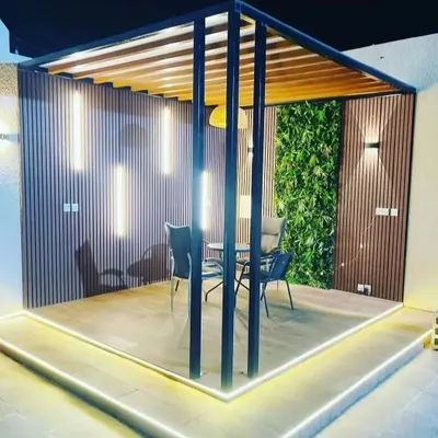 A complete terrace transformation designed for evening ambiance. We integrated a vertical green garden with custom wood paneling, modern lighting fixtures, and a sturdy pergola to create a luxurious outdoor lounge.