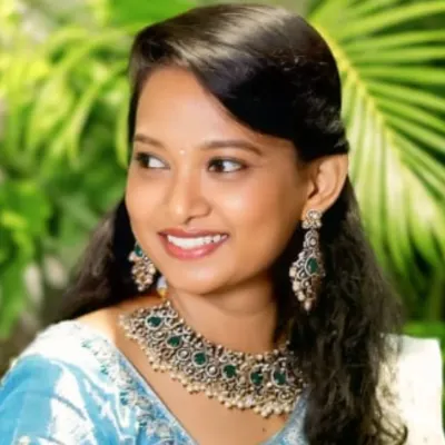 This is a perfect look for a wedding guest or a bridesmaid. My client is wearing a stunning statement choker with green stones that beautifully complements her light blue saree. It's elegant without being overpowering.