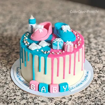 Pink or blue, the surprise is true. This gender reveal cake features a beautiful drip design with both pink and blue chocolate. It's topped with adorable, handcrafted fondant baby shoes and a baby bottle.
