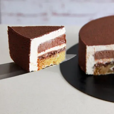 For the true coffee and hazelnut lover, an entremet is the ultimate indulgence. This cake features layers of mousse and cremeux, and this cross-section shows the beautiful textures inside.