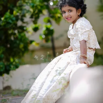 A custom-stitched off-white lehenga set for a little girl. The fabric has a beautiful self-design, and the outfit is designed for comfort, making it perfect for long hours at a family function.