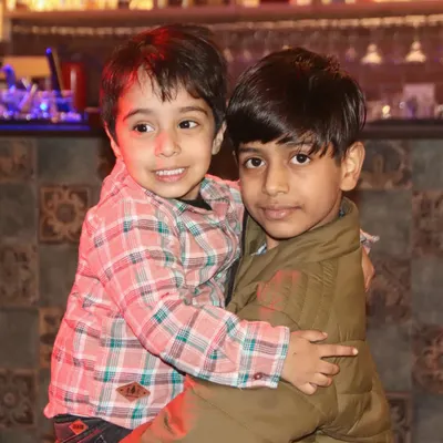A sweet, candid moment of two brothers hugging during a family get-together.